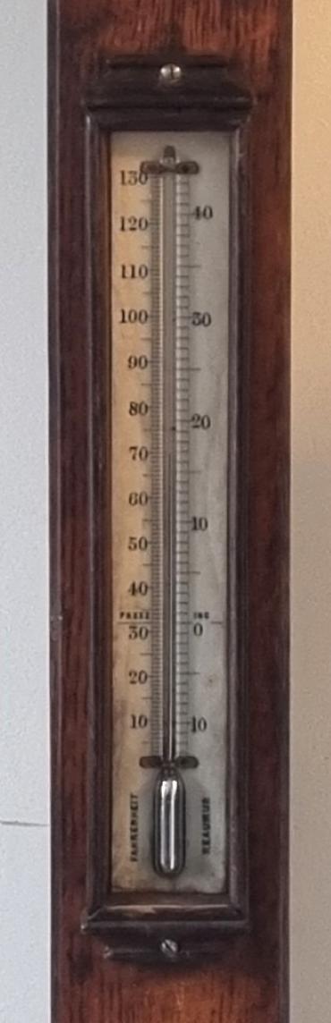 English oak cased mercury barometer and thermometer, circa 1860 by Callaghan of New Bond Street, London. Dark oak mounted flat glass over a white angled dial plate with black inches of mercury pressure indexes and predictive text. Lower oak mounted mercury thermometer displaying temperature in both Fahrenheit and Centigrade.