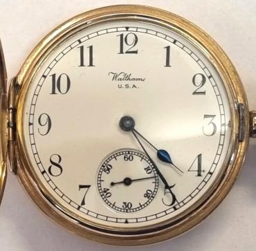 American Waltham Watch Co., full hunter presentation pocket watch in a 9ct gold Dennison case numbered 74548 and hallmarked for Birmingham c1915. Top wind and time change with plain outer case over a white enamel dial with black Arabic hours and blued steel hands with a subsidiary seconds dial at 6 o/c. American P.S. Bartlett grade adjusted 17 jewel jewelled lever movement with split bi-metallic balance and overcoil hairspring with micro-adjuster and numbered 24920049. The inner case cover recording a 1954 retirement presentation to Ernest Hornby celebrating 50 years service.