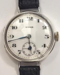 Swiss Cyma Tavannes Officers Style manual wind wrist watch in a silver case with London import hallmark c1923 on a black leather strap with gilt buckle. Signed white enamel dial with black numeric hours and blued steel hands with subsidiary seconds dial at 6 o/c. Swiss signed jewelled lever movement with overcoil hairspring with case back numbered 3305903 8867.