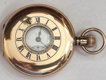 English made half hunter pocket watch in a 9ct gold Dennison case with top wind and time change and hallmarked for Birmingham c1910. Black Roman hours on the outer case and internal white enamel dial with black Roman hours and gilt hands with a subsidiary seconds dial at 6 o/c. English 3/4 plate jewelled lever movement with split bi-metallic balance and overcoil hairspring and numbered 814710 with case back numbered 26960.