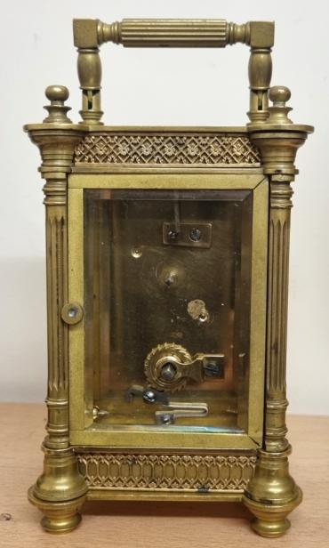 French gilt brass and 5 glass, 8 day carriage clock time piece, maker unknown. Ornate casework with Corinthian style columns and matching carrying handle. Chamfered glass panels throughout and silvered gilt backed floral decorated fretwork mask surrounding a circular enamelled dial with black Gothic hours and blued steel hands and central gilt disk. Plain unmarked brass movement with replacement Swiss lever escapement platform. Height - 5.5" Width - 3.5" Depth - 3".