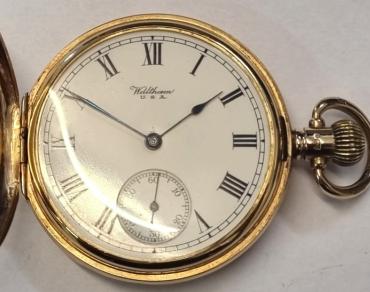 American Waltham Watch Co., full hunter pocket watch in a 9ct gold Dennison case numbered 334564 and hallmarked for Birmingham c1925. Top wind and time change with plain outer case over a signed white enamel dial with black Roman hours and blued steel hands with a subsidiary seconds dial at 6 o/c. American Waltham 15 jewel jewelled lever movement with split bi-metallic balance and overcoil hairspring and numbered 24185261.