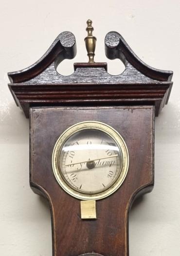 English mid C19th mahogany veneer cased mercury wheel barometer with hygrometer and mercury Fahrenheit thermometer. Swan neck pediment with brass finial and boxwood stringing throughout the lower casework. Circular brass bezel with convex glass over a silvered dial with a black inches of mercury pressure index and blued steel pressure indicating hand with a gilt history marker hand. The alcohol spirit level indicator at the case bottom signed for 'A.P.Boffi, Hastings'. Height - 39" and width - 10.5".