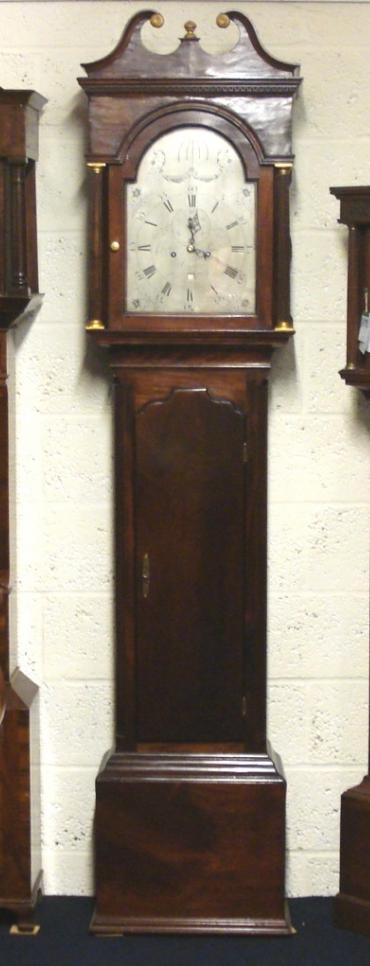 English 8 day bell striking, weight driven and pendulum regulated longcase clock by Charles Penny of Bristol circa 1790. Substantial flame mahogany veneered casework with swan neck pediment with gilt disc and finial decoration and fluted pillars with lower weight and pendulum access door. Signed silvered ornately inscribed dial plate with floral decoration and black Roman hours with black steel hands and subsidiary seconds dial with lower date display aperture. Dimensions - Height 87.5", Width 20.5", Depth 8.5".