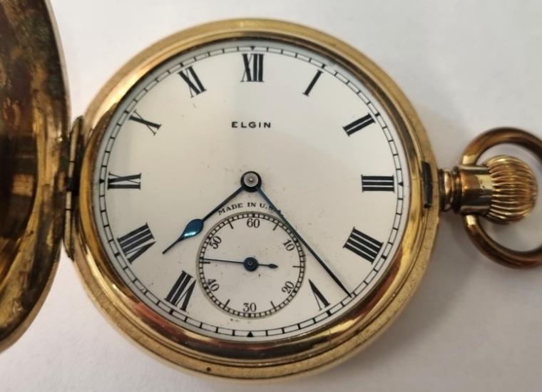 American Elgin National Watch Co half hunter pocket watch in a gold plated Illinois Watch Case Co case with top wind and time change c1930. Black Roman hours on the outer case and internal signed white enamel dial with black Roman hours and blued steel hands with subsidiary seconds dial at 6 o/c. Signed Elgin 7 jewel jewelled lever movement with split bi-metallic balance and overcoil hairspring and numbered 2.9.392348 with case back signed and numbered 3330051. Case diameter 51mm.