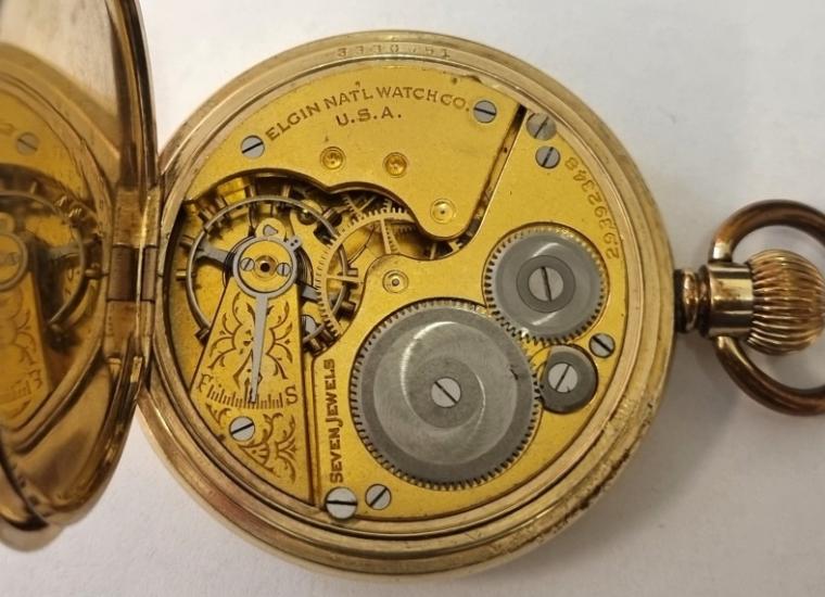 American Elgin National Watch Co half hunter pocket watch in a gold plated Illinois Watch Case Co case with top wind and time change c1930. Black Roman hours on the outer case and internal signed white enamel dial with black Roman hours and blued steel hands with subsidiary seconds dial at 6 o/c. Signed Elgin 7 jewel jewelled lever movement with split bi-metallic balance and overcoil hairspring and numbered 2.9.392348 with case back signed and numbered 3330051. Case diameter 51mm..