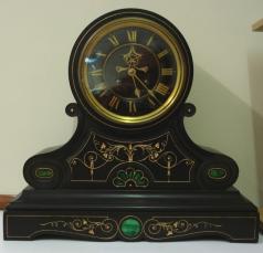 Heavy 8 day scrolling black marble cased mantel clock with malachite inlay and carved and gilded floral motif decoration circa 1890. Circular gilt bezel with flat chamfered glass over a black dial with gilt roman hours and gilt hands, together with the Brocot visible escapement below 12 o'clock and slow/fast adjuster at the dial top. French brass spring driven pendulum regulated movement striking on a bell, maker unknown, but stamped on the back plate #274.