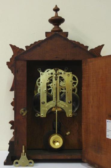 American oak cased 8 day bracket clock by the Ansonia Clock Co. circa 1900. Architectural heavily carved wooden case with turned finial and bracket feet. Circular gilt brass bezel with flat chamfered glass over matt gilt dial with slow / fast regulation at 12 o'clock with black arabic hours and ornate black steel hands. Skeleton square brass gong striking spring driven, pendulum regulated, movement stamped with 'Ansonia Clock Co, New York, USA' and 'Patented June 18,1882'.