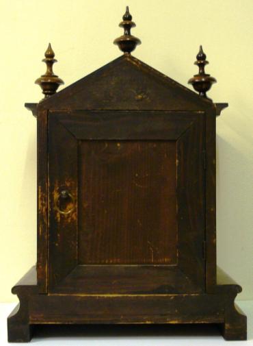 Fruit wood and pine cased 8 day bracket clock circa 1900. Dome topped case with turned finials and side columns on a solid plinth base. Front opening casework with flat glass over steel dial plate with applied gilt spandrels and gilt winged angel head decoration. Silvered chapter ring with matt gilt brass centre and black roman hours with decorative blued steel hands. Square brass gong striking, spring driven, pendulum regulated movement, maker unknown but numbered to the back plate #82449