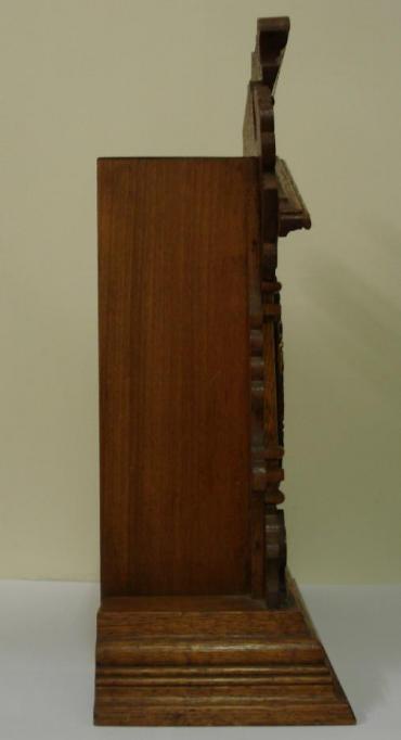 American 8 day oak cased 'Vernon' mantel clock circa 1890, by the Ansonia Clock Co. Highly carved and decorated case with half turned pillars and applied mouldings. Gilt brass bezel with flat chamfered glass over ivorine chapter ring with gilt brass centre. Black gothic hours and ornate black steel hands and slow / fast adjuster at 12 o'clock. Spring driven, gong striking skeletonised brass movement with original pendulum, and stamped 'Ansonia Clock Co.' and 'Patented - June 18, 1882'.