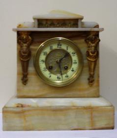 French 8 day white marble cased mantel clock circa 1890. Architectural square case with decorative applied ormolu mouldings and gilt circular bezel with flat chamfered glass over an ivory enamel chapter ring with silvered and gilt fretwork centre. Black gothic hours and ornate blued steel hands and slow / fast adjuster at 12 o/c. Good quality pendulum regulated, spring driven, gong striking French brass drum movement with an 'AD Mougin' 'Deux Medailles' touch mark and numbered #44.  Dimensions: Height - 11.5", width - 10.25", depth - 6.25".