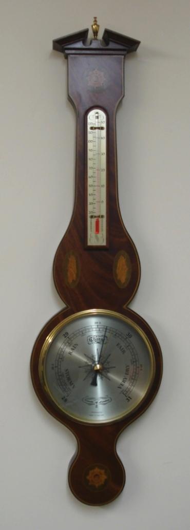 Modern Comitti of London compensated barometer in a wood veneer case with marquetry inlay. Circular gilt brass bezel over a silvered dial with black painted index and a separate alcohol Centigrade and Fahrenheit thermometer.