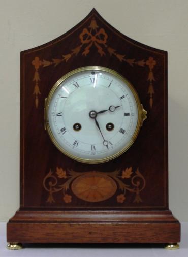 French 8 day walnut cased mantel clock striking on a gong, circa 1870. Elegant lancet topped case with extensive floral themed  marquetry inlay and  integral plinth with brass bun feet. Gilt brass bezel with convex  glass over an enamelled convex dial with black roman hours and black steel moon hands, slow / fast adjust at 12 o'clock. Ornate brass rear door with sound frets over a good quality French brass drum, spring driven pendulum regulated, movement by Vincenti. Movement and pendulum both numbered #66655 and the movement stamped with the Vincenti mark incorporating a 'Medaille d'Argent - 1855' award.