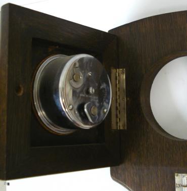 British made oak cased 8 day clock and aneroid barometer. Square chromed bezel with domed glass over an ivory chapter ring with black painted roman hours and chromed hands. Circular chromed bezel over a silvered dial barometer with inches of mercury index. Separate alcohol Fahrenheit and Centigrade thermometer. Clock movement hinges forward to reveal time change, fast / slow adjust and wind controls.