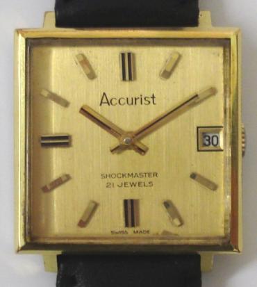 Accurist Shockmaster manual wind wrist watch in a square gold plated case with stainless steel back, on a black leather strap with gilt buckle. Brushed gilt dial with gilt baton hour markers and matching hands, date display at 3 o/c. Signed swiss Peseux calibre 7046 21 jewel incabloc movement.