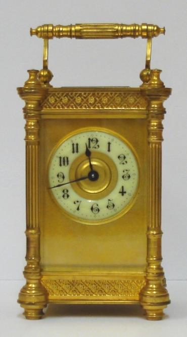French gilt brass and 5 glass, 8 day carriage clock time piece circa 1900, maker unknown. Ornate casework with Corinthian style columns and matching carrying handle, together with open fretwork panels at top and bottom on each side. Chamfered glass panels throughout and gilt matt mask to the circular ivorine dial which has black Gothic hours and blued steel hands and a central gilt disk. Plain unmarked brass movement with contemporary cylinder escapement. 