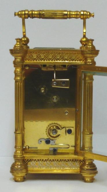 French gilt brass and 5 glass, 8 day carriage clock time piece circa 1900, maker unknown. Ornate casework with Corinthian style columns and matching carrying handle, together with open fretwork panels at top and bottom on each side. Chamfered glass panels throughout and gilt matt mask to the circular ivorine dial which has black Gothic hours and blued steel hands and a central gilt disk. Plain unmarked brass movement with contemporary cylinder escapement. 
