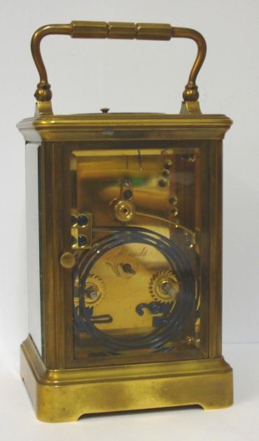 French gilt brass and 5 glass, 8 day strike / repeat carriage clock circa 1880 by Henri Jacot. Corniche case with chamfered glass panels throughout, white enamel dial with black Roman hours and minute track and blued steel hands. Back plate with Jacot arrow and numbered #6702 below a contemporary silvered jewelled lever escapement. 'Hidden' oval Henri Jacot stamp applied internally to the back of the dial plate. Height - 7.25" Width - 3.75" Depth - 3.25".