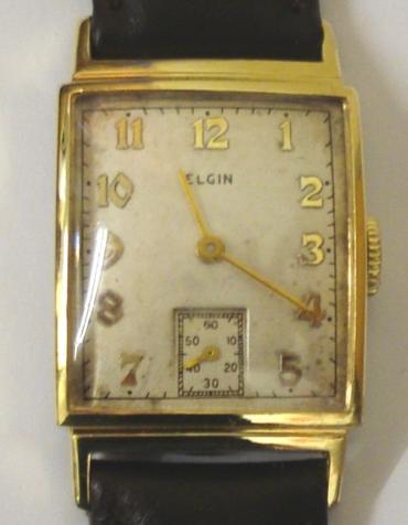 American Elgin manual wind wrist watch in a gold plated case with base metal back on a brown leather strap with gilt buckle. Silvered dial with gilt arabic hour markers and matching hands and subsidiary seconds dial. Signed 15 jewel movement numbered C667671 with case back numbered #7412317.