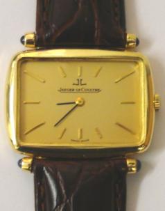 Swiss Jaeger LeCoultre manual wind wrist watch in a 18ct gold case on a brown leather strap with gilt buckle. Gold coloured dial with gilt baton hour markers and black and gilt hands. Signed jewelled lever movement with case numbered #4459 21 and #1350038 with London import hallmark for 1972.