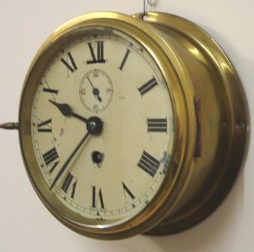 English heavy brass 8 day ship's clock timepiece c1940. Thick flat glass over a distressed ivory painted dial with black Roman hours and minute track and black steel hands with subsidiary seconds dial and slow / fast control at 12 o/c.  Dimensions - Height and width 7.25" and depth 3".