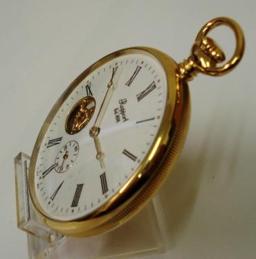 New gold plated open face pocket watch by the Rapport Company. White dial with gold coloured hands and black painted hour markers, subsidiary seconds dial at 6 o'clock and visible balance. Mechanical 17 jewel skeletonised movement, with stem wind and time adjust. Original box and gold plated watch chain with 'T' bar and bow snap.