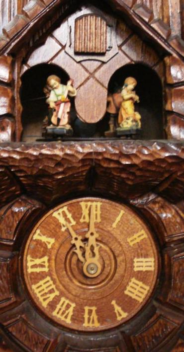 New 3 weight driven 8 day duration cuckoo clock with cuckoo displaying on the hour and half hour and striking on a gong. Decorative carved case with castle themed building, and vine leaf pendulum. The clock features an automaton of dancing figures, and a two tune musical movement.