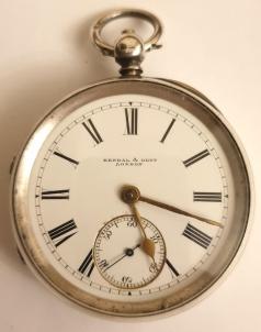English silver cased pocket watch by Kendal & Dent, London in a case bearing a Birmingham hallmark for circa 1896. Key wind and time change with signed white enamel dial and black Roman hours with gilt hands and subsidiary seconds dial. Signed going barrel movement with floral decorated cock piece and jewelled end stone and with inscription '106 Cheapside, London' and numbered #82226, the number repeated on the case back with the 'K&D' stamp.