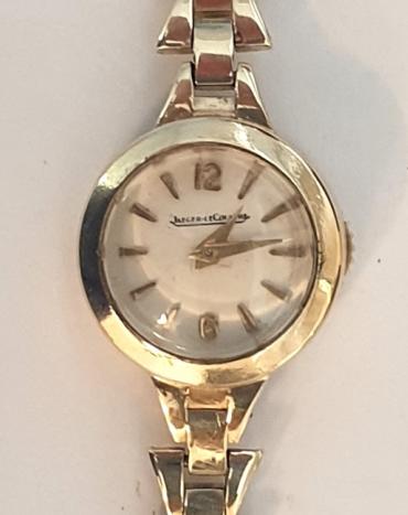 Ladies Swiss Jaegar LeCoultre manual wind wrist watch in a 9ct gold case with integral 9ct gold bracelet hallmarked for London circa 1961. Signed silvered dial with gilt hour markers and matching gilt hands. Signed jewelled lever movement numbered #49836 with back wind and time change function. 