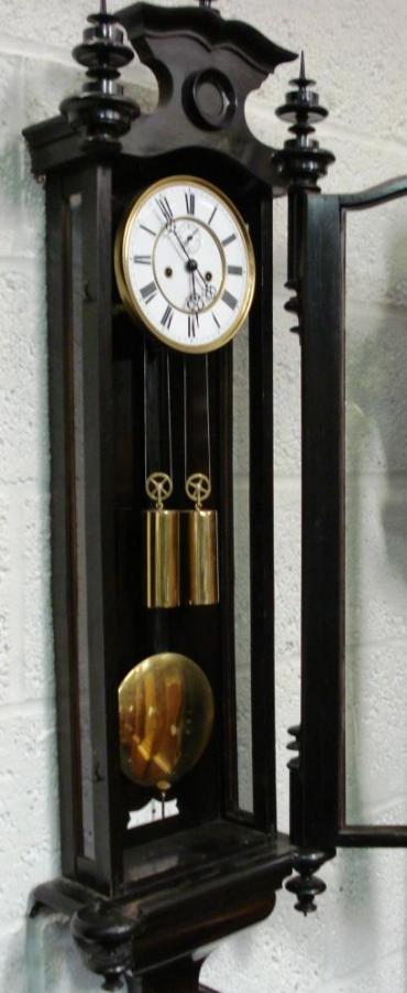 Ebonised cased 8 day, key wound, weight driven, gong striking, Vienna style Regulator movement, dating from c1880. Casework incorporates turned wood finials and full length glazed door. White enamel dial with black roman hours and ornate steel hands and subsidiary seconds dial.