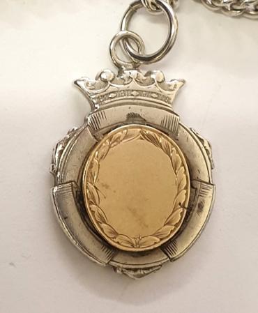 Early c20th silver double pocket watch chain with 'T' bar, single snap and decorative silver and gold inscribed presentation medallion hallmarked for Birmingham 1923.    Length 8", weight 37 grams.
