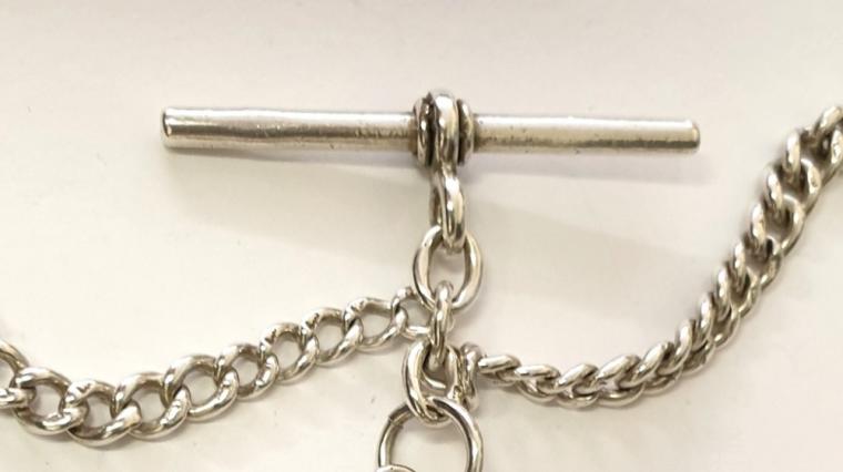 Early c20th silver double pocket watch chain with 'T' bar, single snap and decorative silver and gold inscribed presentation medallion hallmarked for Birmingham 1923.    Length 8", weight 37 grams.