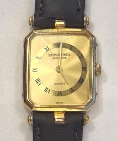 Modern Ladies 18k gold plated quartz wrist watch by Raymond Weil of Geneva on a brown leather strap with gilt buckle. Champagne coloured dial with black Roman hours on a polished gilt chapter ring with matching gilt hands.