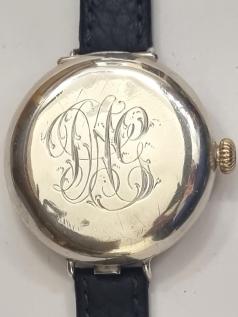 WWI Rolex Officer Style manual wind wrist watch in a silver hunter case with London import hallmark for c1916, on a black leather strap with silvered buckle. White enamel dial with black Arabic hours and blued and luminous steel hands with subsidiary seconds dial at 6 o/c. Swiss made jewelled lever movement with gilt crown and case back bearing the Rolex 'W&D' mark and numbered 1108.